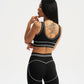 Person wearing a black sports bra and leggings set on a white background