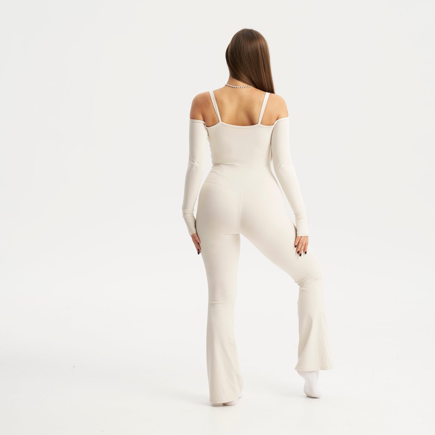 Woman wearing a white bodysuit on a white background