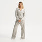 Woman wearing a gray tracksuit on a white background