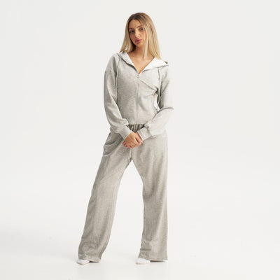 Woman wearing a gray tracksuit on a white background