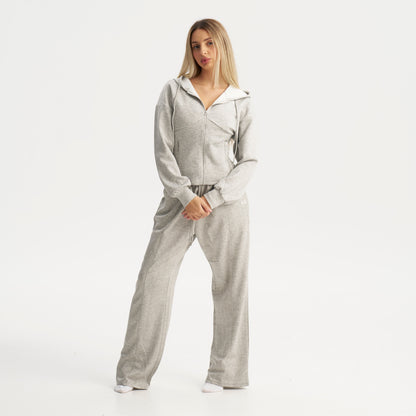 Woman wearing a gray tracksuit on a white background